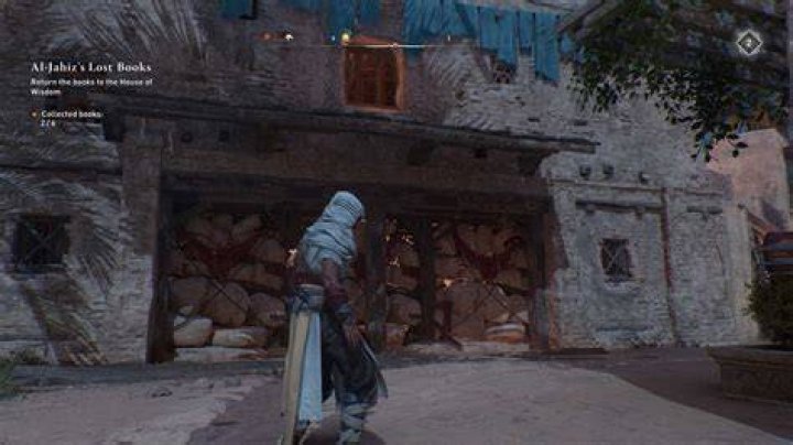 Basim stands near a breakable wall in AC Mirage while looking for Gear Chests.
