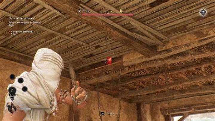 Basim throws a throwing knife at a straw floor in Harbiyah looking for the Gear Chest in AC Mirage.