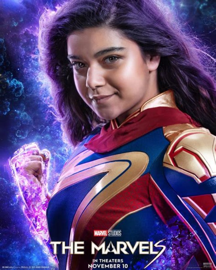 Iman Vellani as Ms. Marvel/Kamala Khan, Brie Larson as Captain Marvel/Carol Danvers, and Teyonah Parris as Captain Monica Rambeau stand together in costume, all looking up, in the Marvel Cinematic Universe movie The Marvels