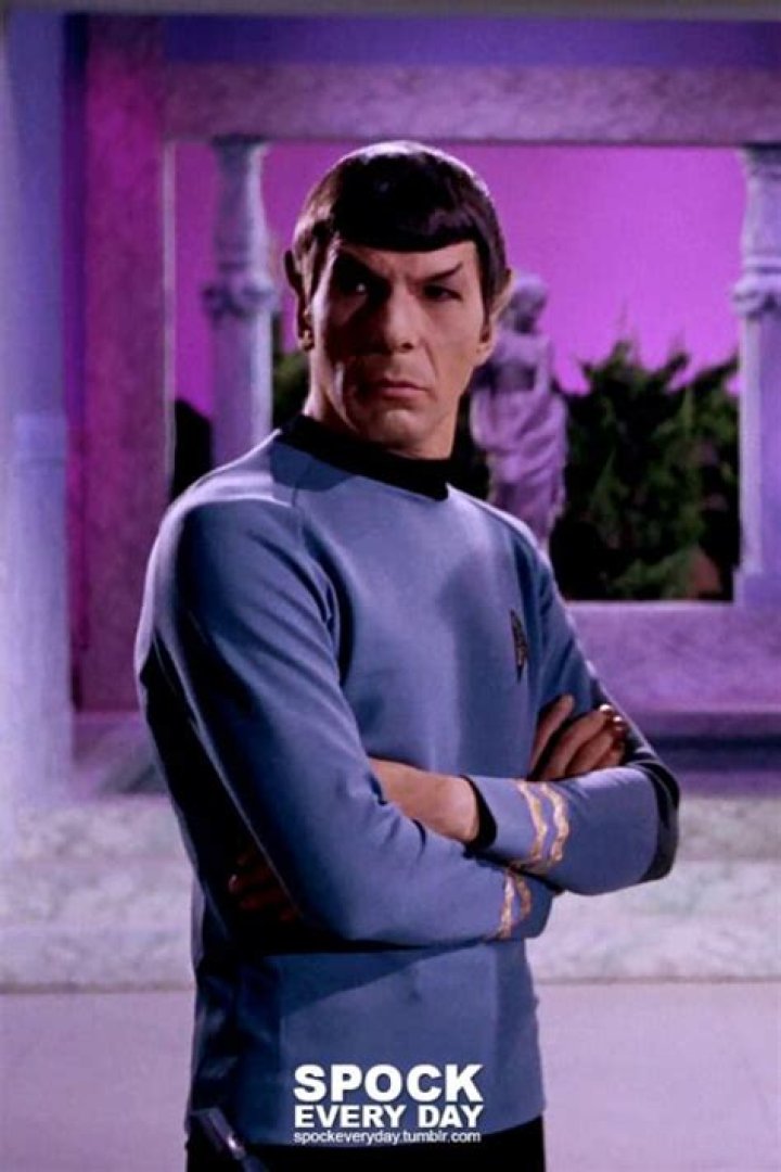 Spock standing with his arms behind his back on the bridge, while Pike, Kirk, and Uhura look at him from the side