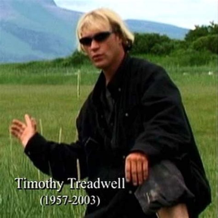 Timothy Treadwell poses in front of a grizzly bear